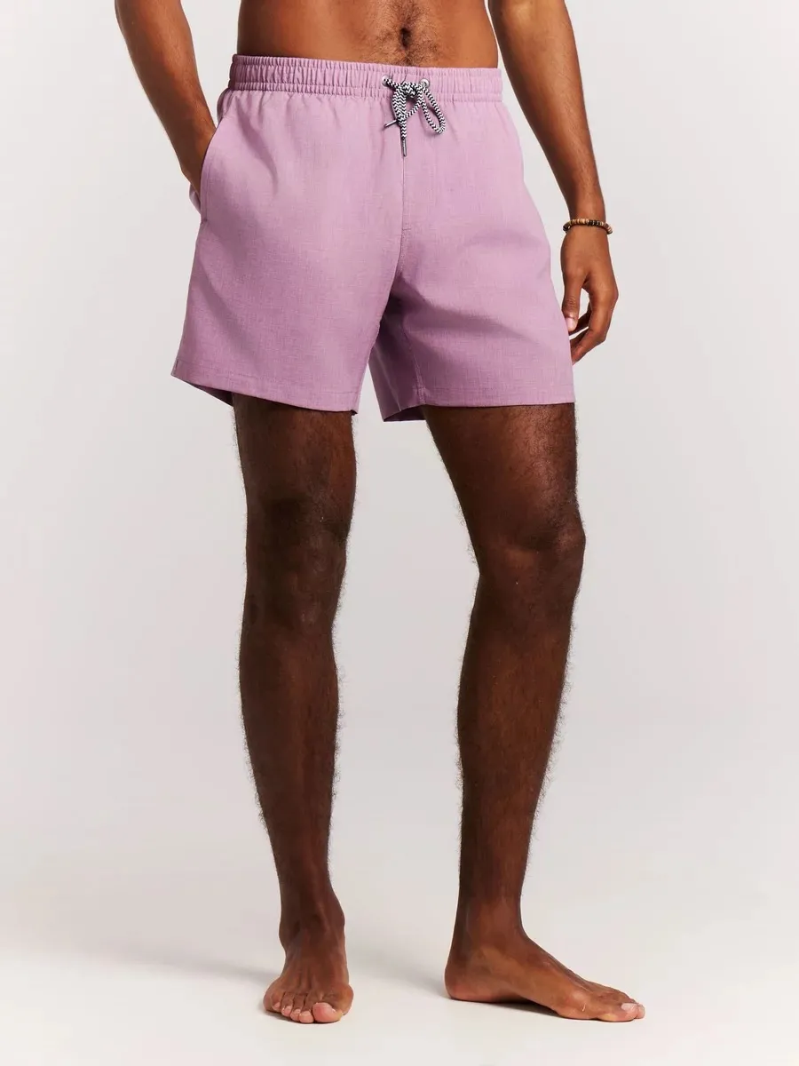 Ein Mann mit brauner Haut trägt eine mauvefarbene Protest Daviey Beachshort mit Kordelzug.