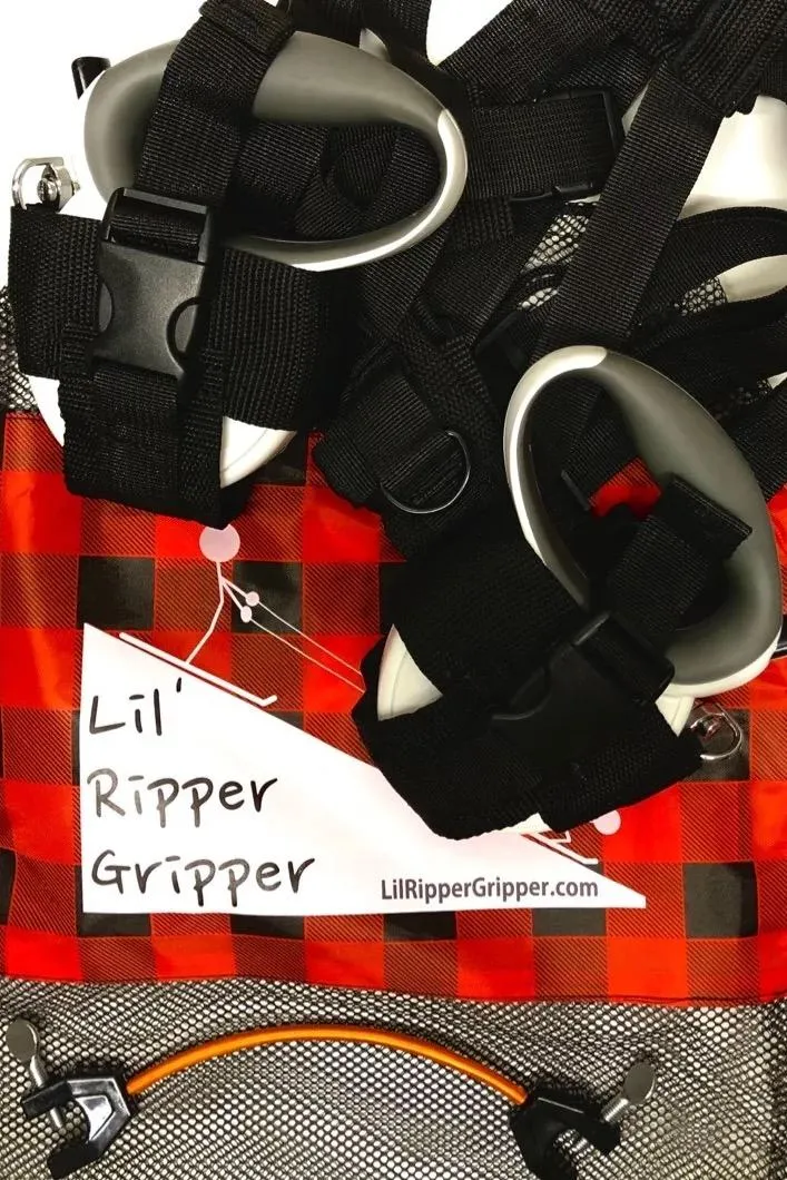 Lil' Ripper Gripper: Detailaufnahme der Ski-Lernhilfe mit Leinen, Gurt, Griffen und Skispitzenhalter auf rot-schwarz kariertem Stoff.