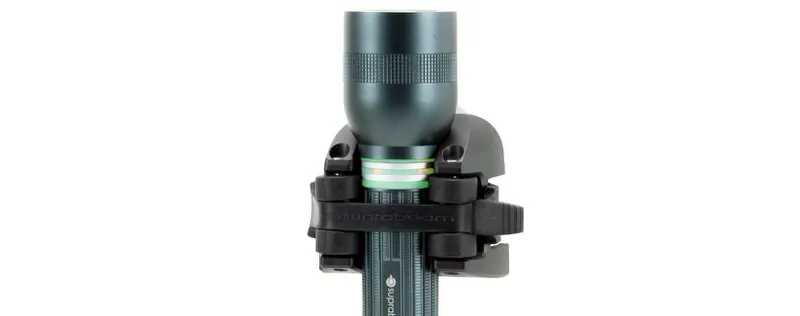 Dunkelgraue Suprabeam Q5xr Defend LED Taschenlampe, befestigt in einer schwarzen Halterung, vor weißem Hintergrund.