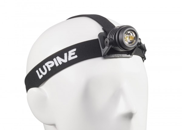 LUPINE Neo X2 Stirnlampe Nahaufnahme einer Neo X2 Smartcore Stirnlampe auf einem weißen Styroporkopf. Das schwarze Stirnband trägt den weißen Schriftzug "LUPINE".
