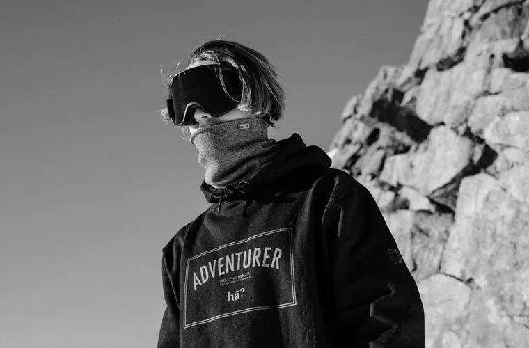 Schwarz-weiß Aufnahme: Person mit Skibrille und Drifter Merino Neckwarmer vor felsigem Hintergrund.