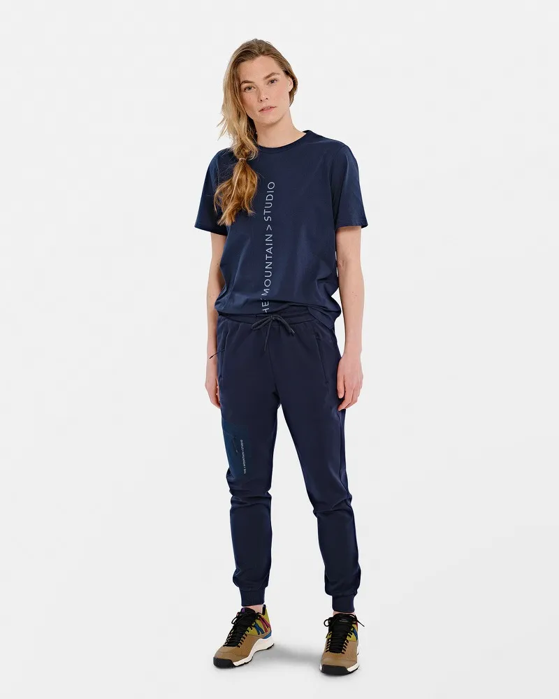 Person in marineblauem T-Shirt mit vertikalem Logo und passender Hose.