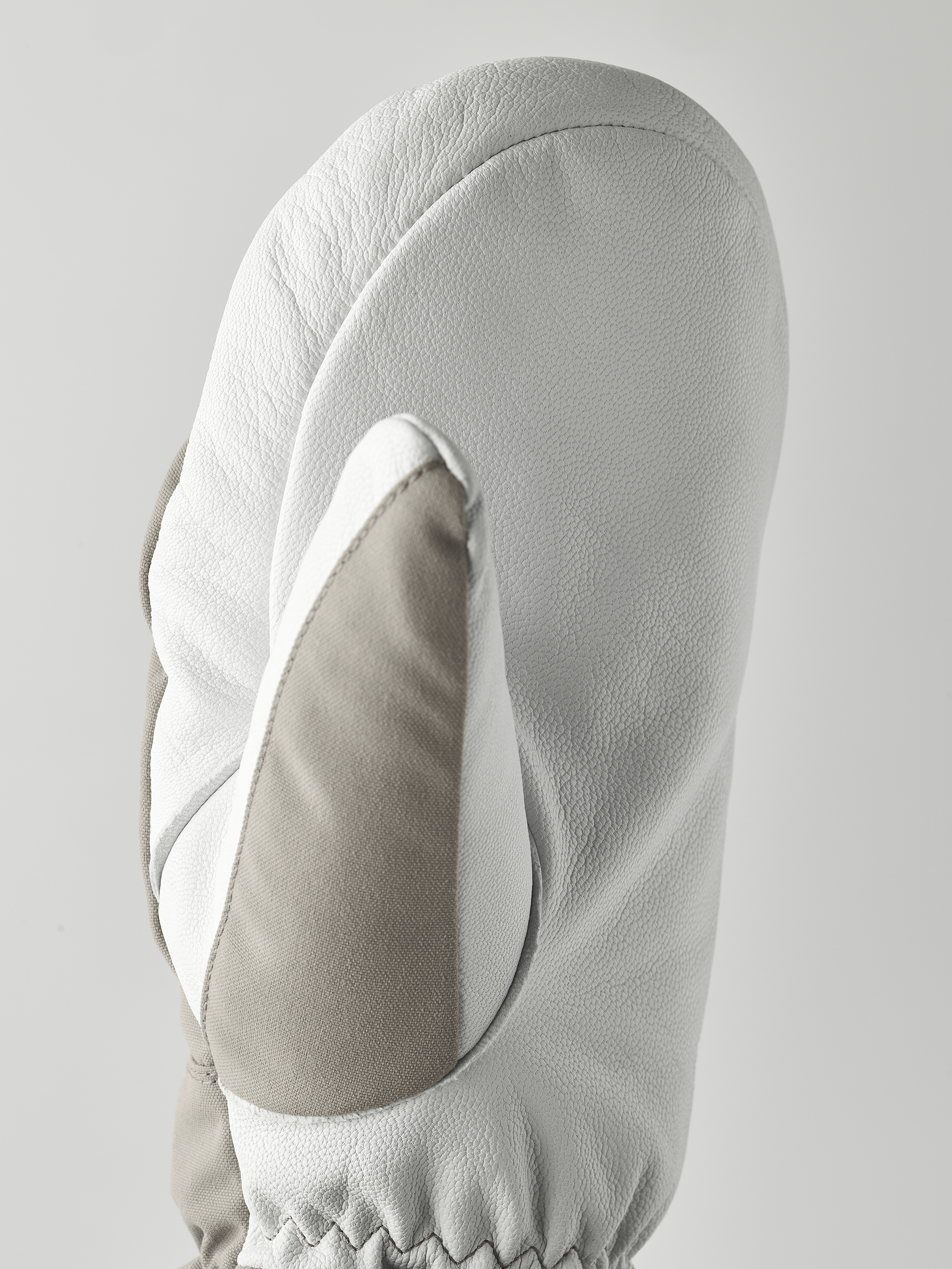 Detailansicht von Hestra Army Leather Heli Ski Mitt in Grau und Weiß. Lederstruktur ist erkennbar.