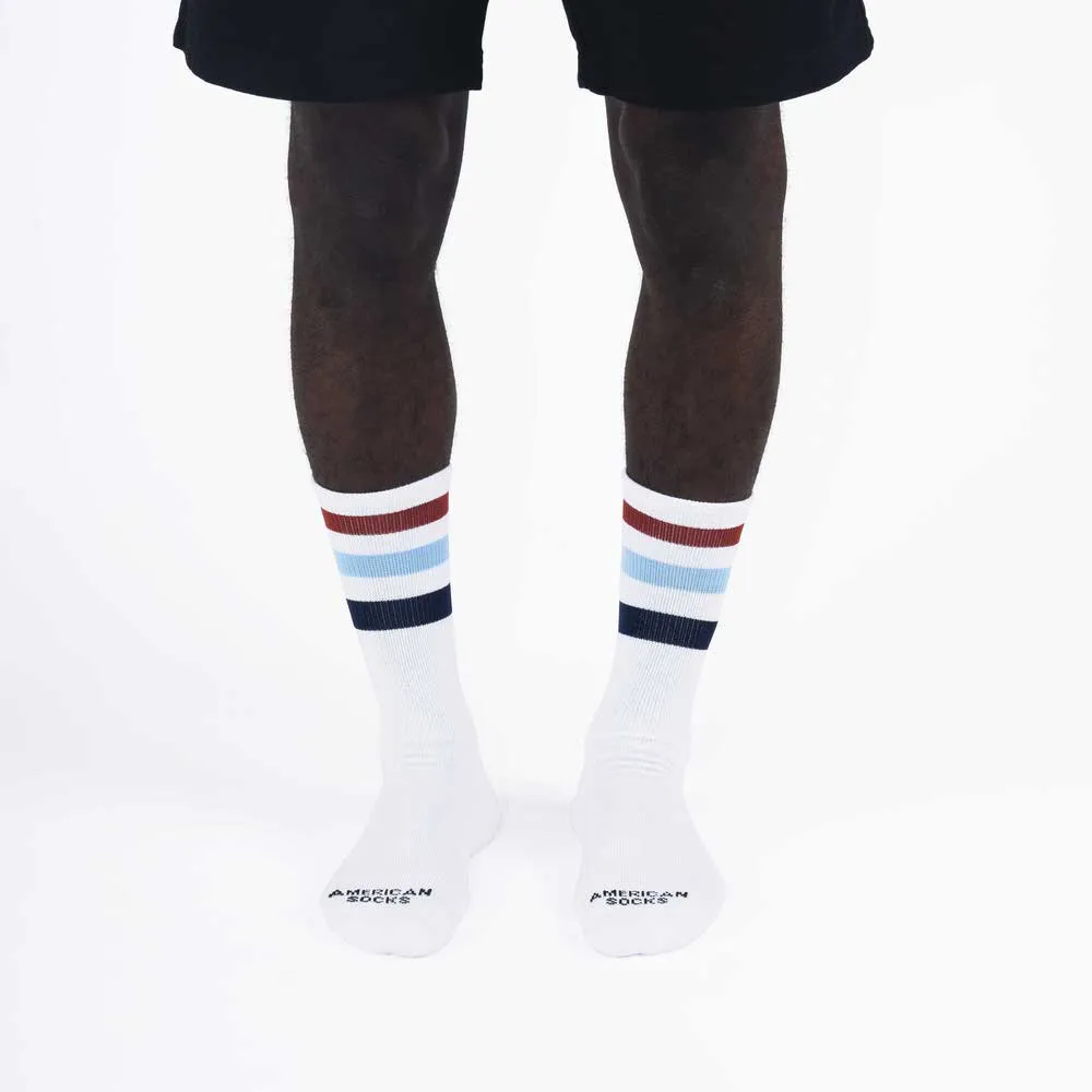 Beine mit weißen Mid High Socken, farbige Streifen (braun, hellblau, blau) am oberen Sockenrand.