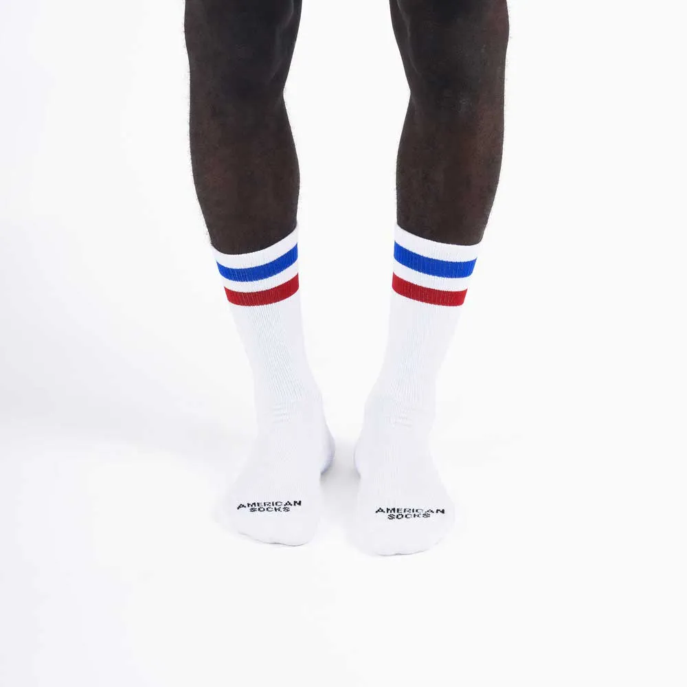 Weisse Mid High Socken mit rotem und blauem Streifen getragen von einer Person.