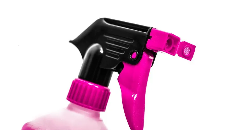 Nahaufnahme: Sprühkopf in Pink und Schwarz einer Reinigungsflasche vor weissem Hintergrund.