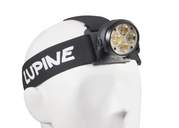 Schwarze Wilma RX 7 Stirnlampe mit vier LEDs an weißem, formlosen Kopf befestigt. Das Stirnband trägt den Schriftzug "Lupine".