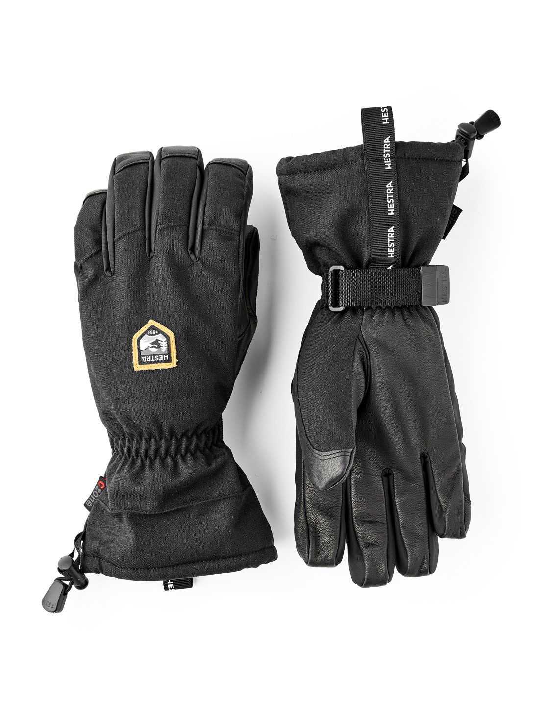 Hestra-Handschuhe Set Zwei schwarze Hestra-Handschuhe, einer mit Stoffstulpe und Kordelzug, der andere mit Lederhandfläche und Gurtband.