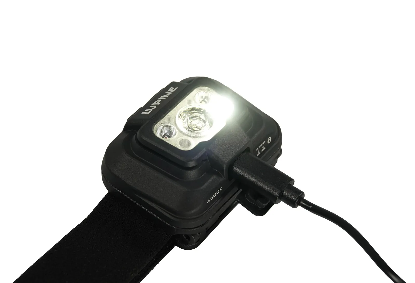 Schwarze Penta 4500k Stirnlampe, am Ladekabel, mit eingeschaltetem, hellem Licht.