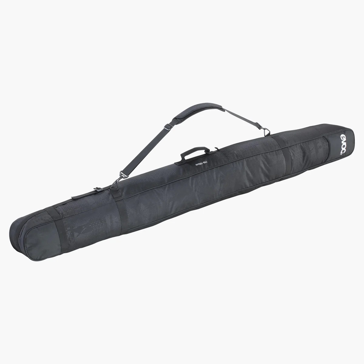Eine schwarze Evoc Ski Bag liegt diagonal im Raum. Sie hat einen Tragegurt und einen Griff.