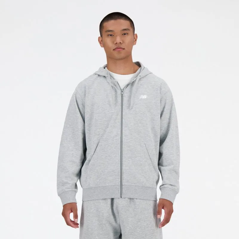 Mann trägt einen grauen New Balance French Terry FZ Hoodie mit durchgehendem Reißverschluss und Kapuze. Vorne ist ein NB-Logo zu sehen.