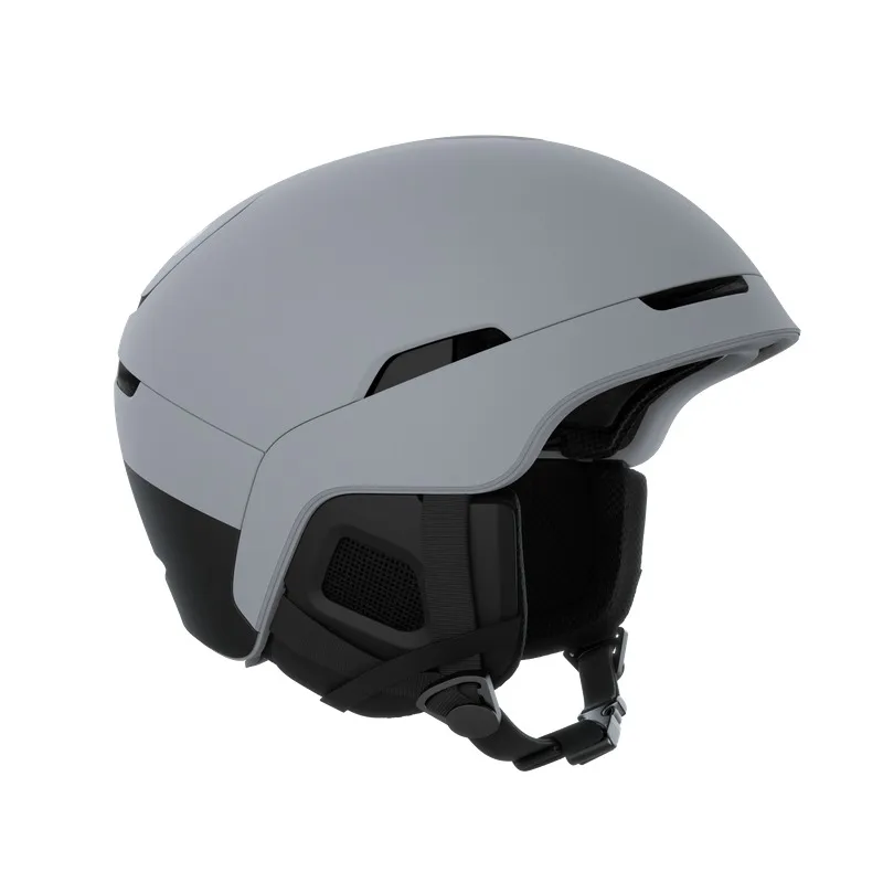 Ein grauer Skihelm mit schwarzen Akzenten, Seitenpolsterung und Kinnriemen auf einem weißen Hintergrund.