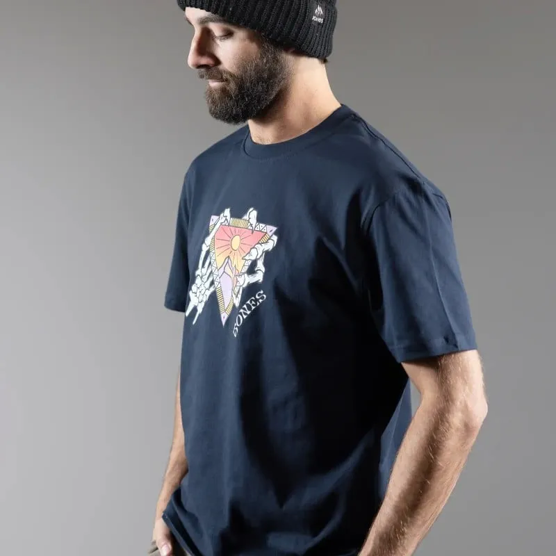 Mann mit Mütze, trägt dunkelblaues T-Shirt mit Grafikdruck: Sonne, Dreieck und Handknochen.