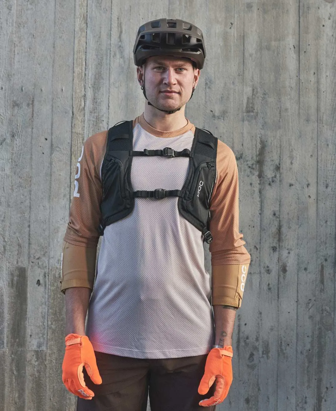 Mann mit Fahrradhelm, orange Handschuhen und Column VPD Backpack. Der Rucksack hat zwei Brustgurte.