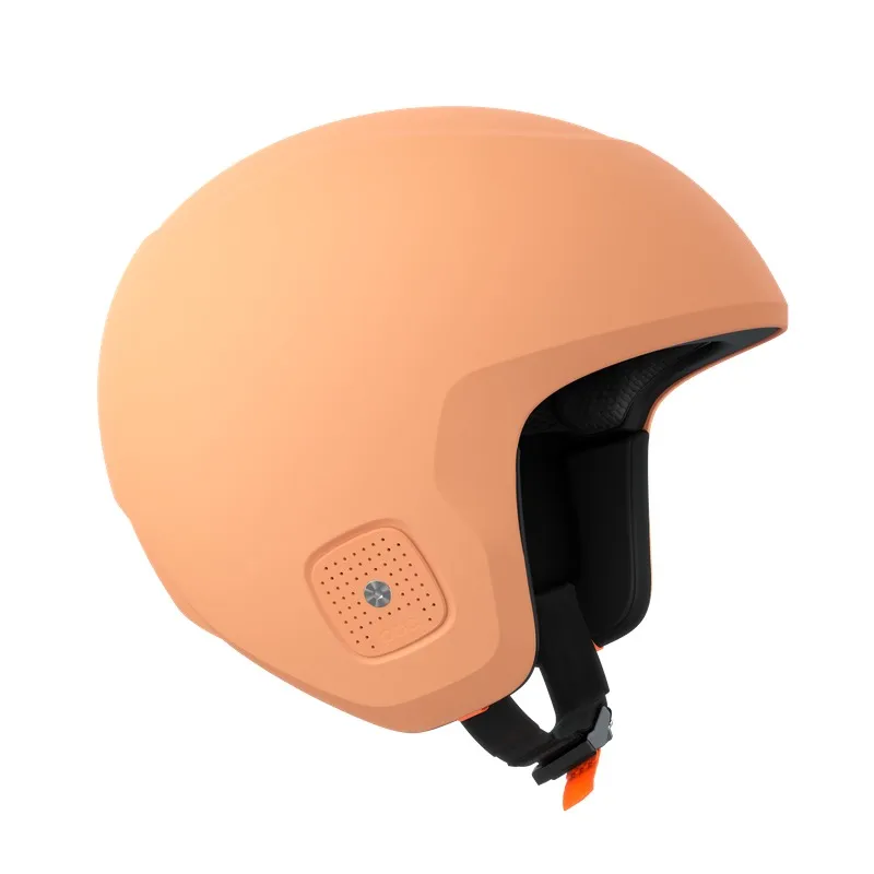 Pfirsichfarbener Skihelm mit Belüftungslöchern und schwarzem Kinnriemen, seitlich leicht versetzt aufgenommen.