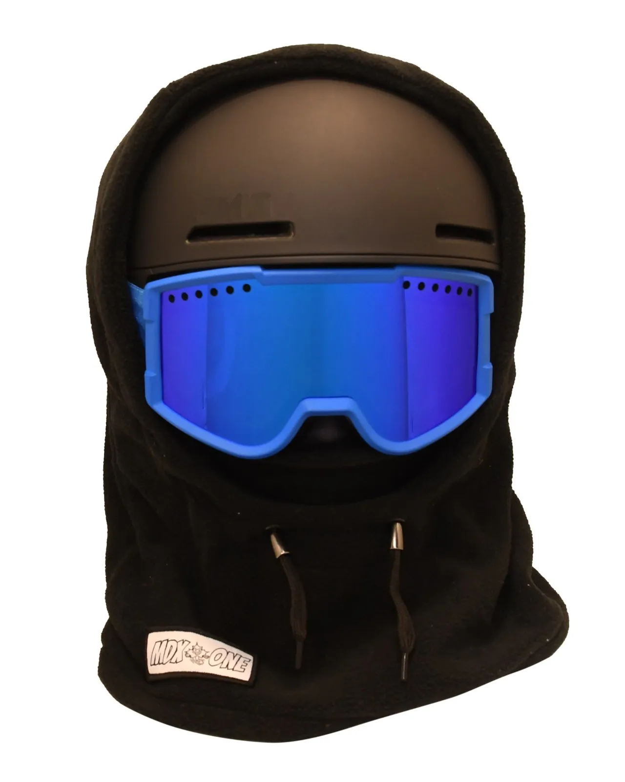 Schwarze Kinder-Sturmhaube aus weichem Polar-Fleece über schwarzem Skihelm und blauer Skibrille. Bedeckt Kopf, Hals und Gesicht für optimalen Kälteschutz, ideal zum Skifahren und für Wintertage. Unten links: weißes Etikett "MDX-ONE".