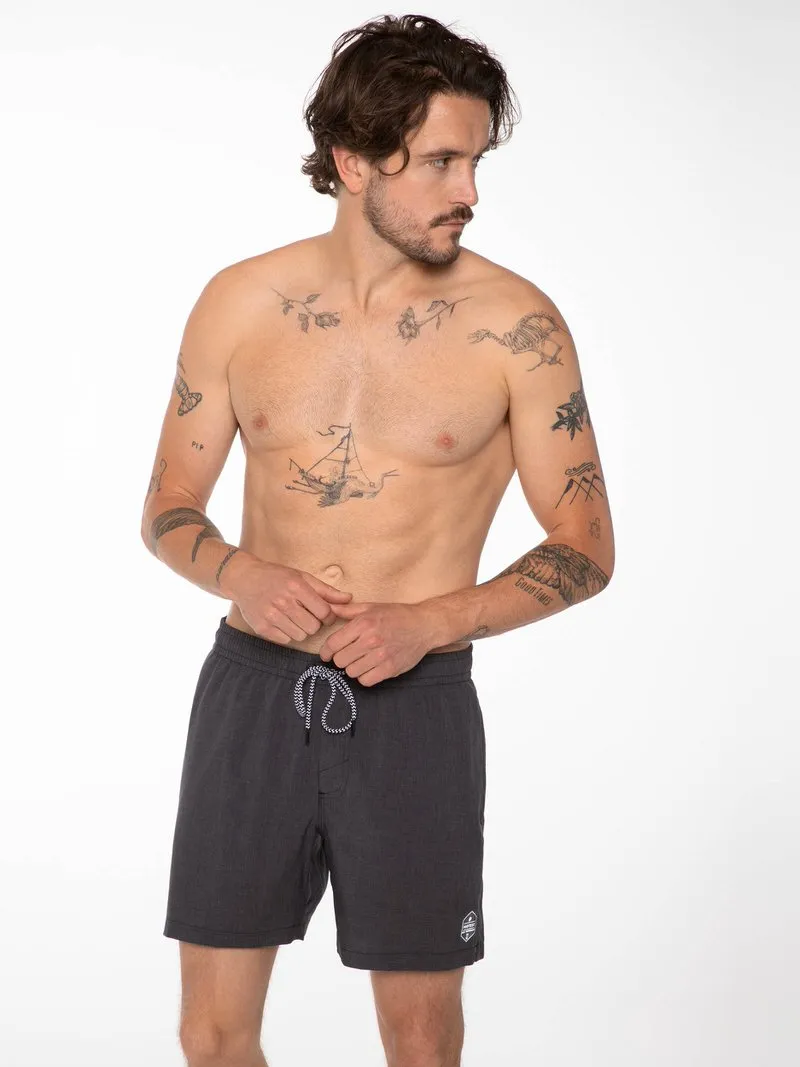 Ein Mann mit Tattoos trägt die schwarzen Davey Badeshorts mit Kordelzug.