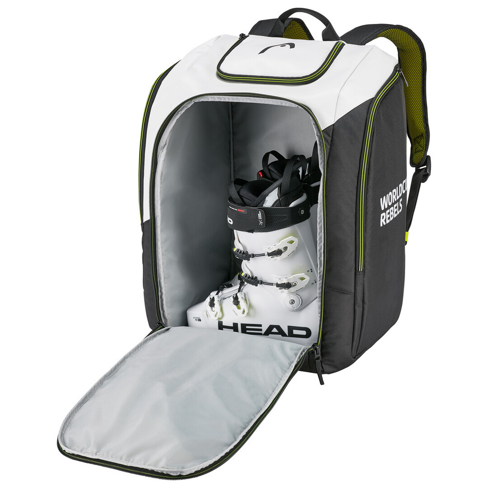 Geöffneter Head Rebels Racing Backpack S, zeigt Skischuh im Hauptfach. Weiß, schwarz, mit Tragegurten.