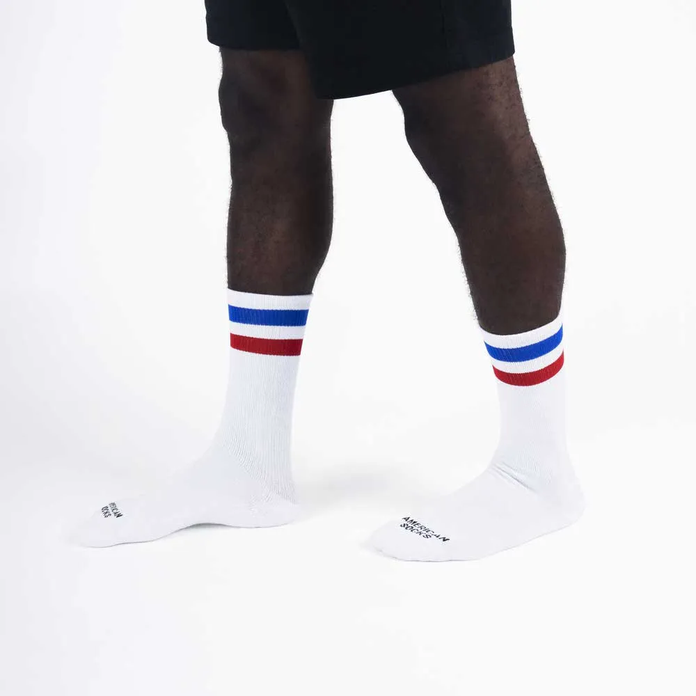 Beine mit weißen Mid-High Socken mit blauen und roten Streifen am Bündchen.