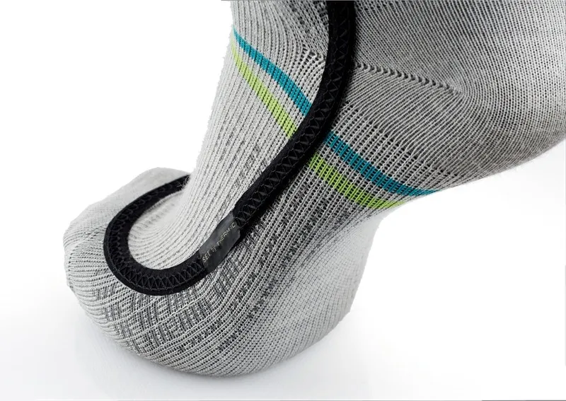 Detailaufnahme einer grauen Ski Heat Race S.E.T Socke mit blauen und grünen Streifen und schwarzem Heizelement.