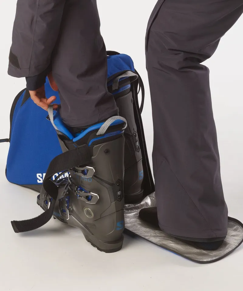 Salomon Skischuhe werden in eine blaue Original Gearbag Skischuhtasche gepackt.