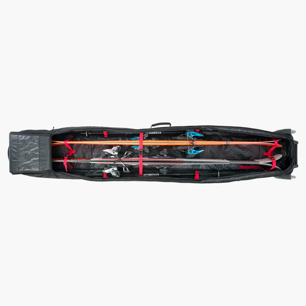 Evoc Ski Roller Set Offener Evoc Ski Roller mit Skiern und Stöcken, gesichert durch rote Gurte.