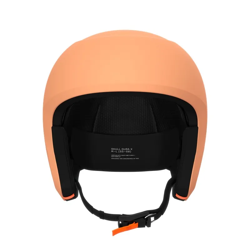 Ein pfirsichfarbener Skihelm, von vorne gesehen, mit schwarzer Innenausstattung und Kinnriemen.