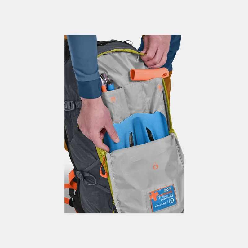 Geöffneter Ortovox Avabag Litric Tour 30 Rucksack in Black Steel Farbe mit Skitouren Ausrüstung und blauer Helmhalterung.