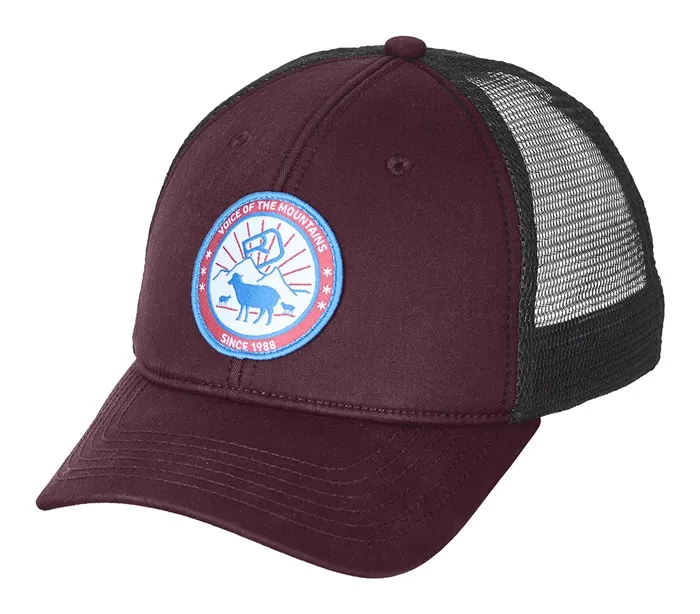 Weinrote Trucker Cap mit schwarzem Mesh-Einsatz und rundem Aufnäher mit Bergszene und Schaf.