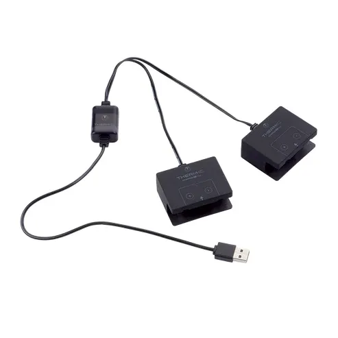 Schwarzes, elektronisches Gerät mit zwei Pads, Kabeln, einem USB-Stecker und einem kleinen Adapter.