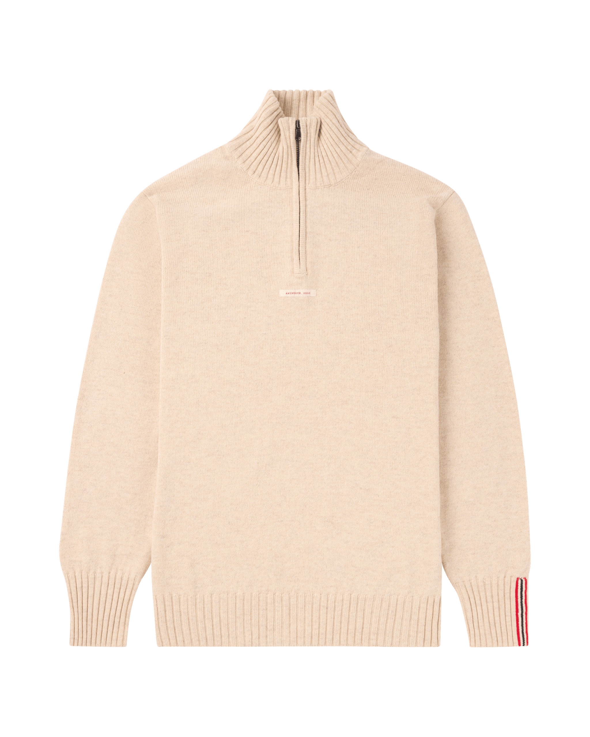 Beiger Strickpullover mit kurzem Reißverschluss am Kragen und rot-weiß-blauen Streifen am Ärmel.