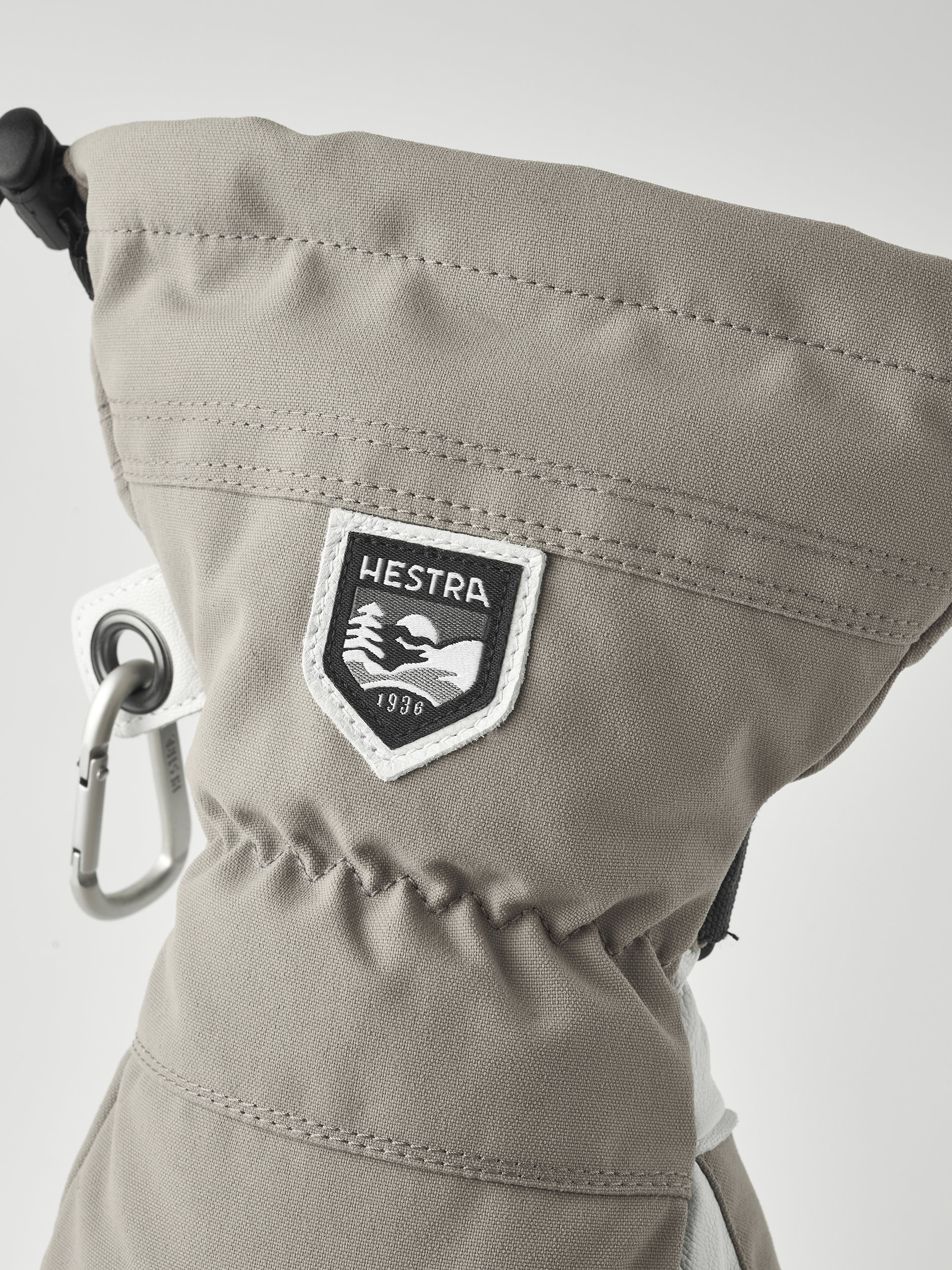 Hestra Army Leather Handschuh Detailaufnahme des Hestra Army Leather Heli Ski Mitt, mit Logo und Karabinerhaken.