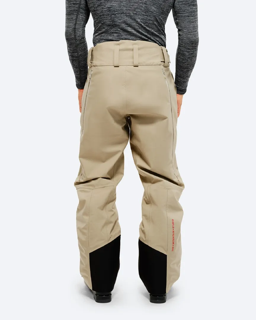 Rückansicht der "P-7 Ride Insulated Pant Seneca Rock" in Beige mit schwarzen Verstärkungen am Beinende.