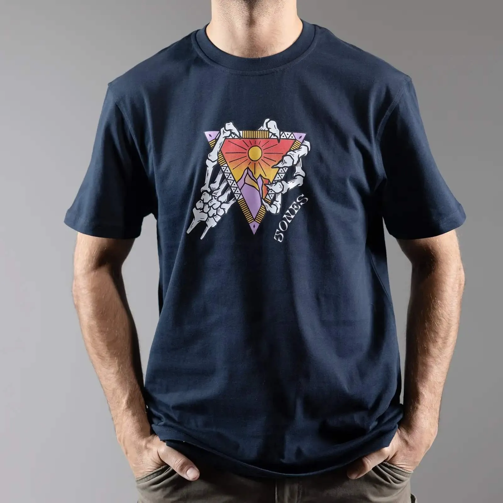 Navy Jones Organic Cotton Tee mit Berg, Sonne und Skelett Hände Grafik Design.
