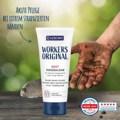 Handbalsam-Tube "Workers Original" neben schmutziger Hand vor grünem Hintergrund auf Holz mit Schaufel.