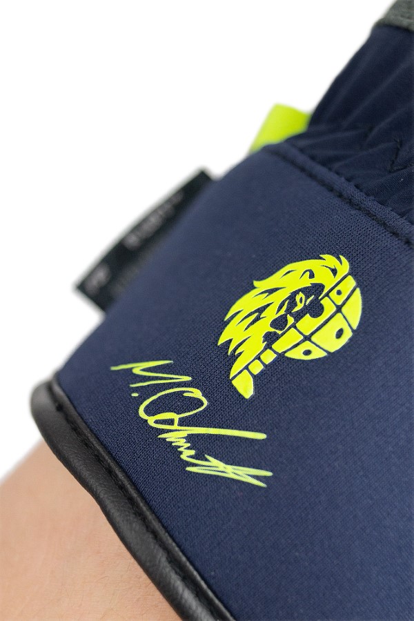 Reusch Rennhandschuh Detail Detailansicht vom Reusch Rennhandschuh mit gelbem Logo und Schriftzug auf dunkelblauem Stoff.