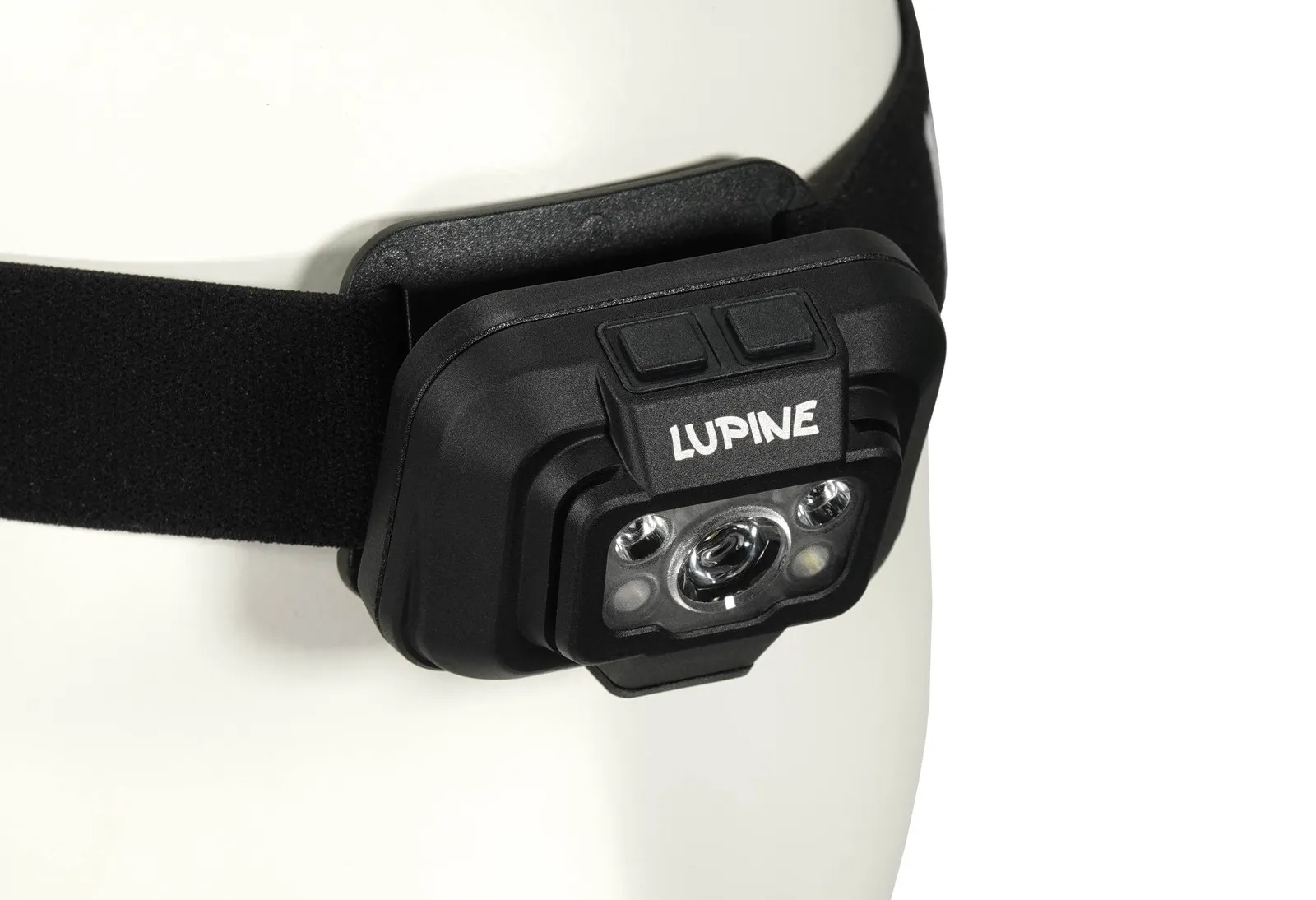 Nahaufnahme einer Penta Stirnlampe mit schwarzem Stirnband an einem weißen Kopf. "Lupine" Schriftzug.