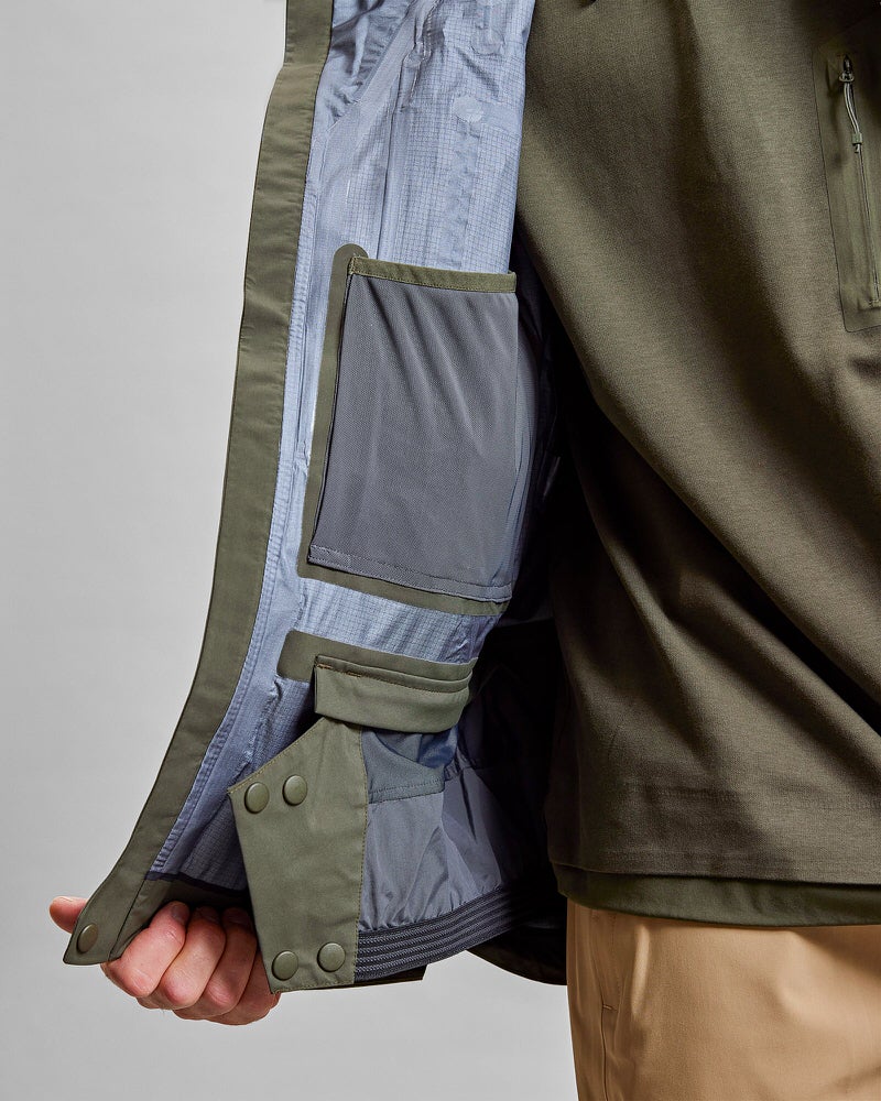 Detailaufnahme: Innenseite einer grünen Z-2 HD GORE-TEX Pro 3L Shell Jacket mit Taschen.