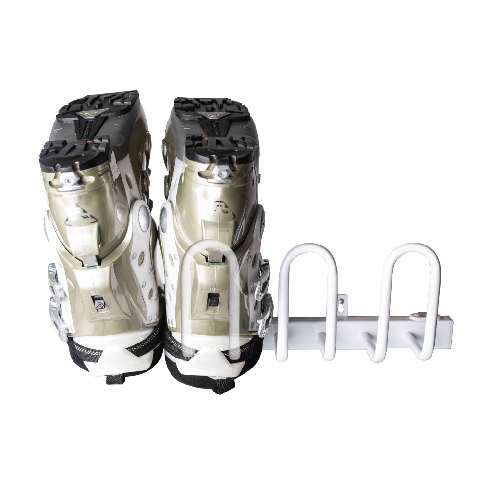 Zwei Skischuhe, von hinten gesehen, hängen an einem weißen, horizontalen Metallständer mit U-förmigen Halterungen.