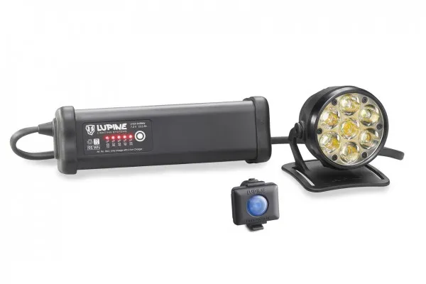 Schwarze Betty R 14 Helmlampe mit Akku, Fernbedienung und Helmhalter auf weißem Hintergrund.