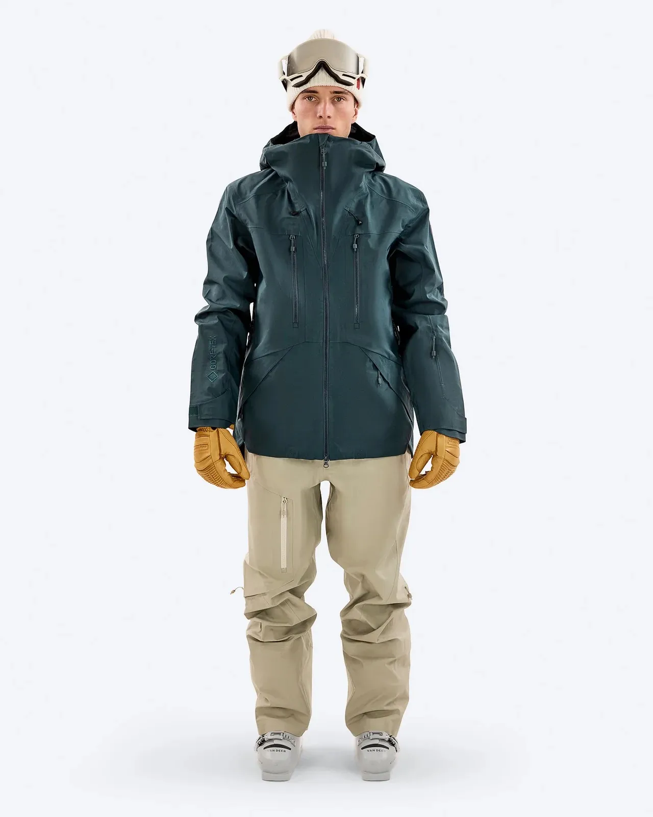 Person in Ski-Jacke "Magic Forrest", Hose, Handschuhen und Mütze vor weißem Hintergrund.