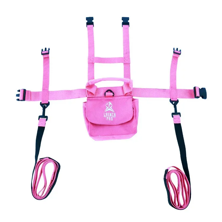 Pinkfarbenes Kleinkinder-Skigeschirr mit Leine: verstellbare Schultergurte und gepolsterter Mittelbereich mit „LAUNCH PRO“-Logo und Tragegriff. Zwei abnehmbare schwarz-pinke Leinen seitlich, unten aufgerollt. Mehrere Schnallen.