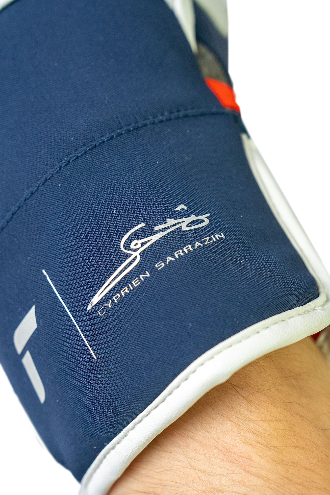 Marineblaue Manschette Nahaufnahme einer marineblauen Manschette mit weißem Rand, signiert mit "Cyprien Sarrazin".