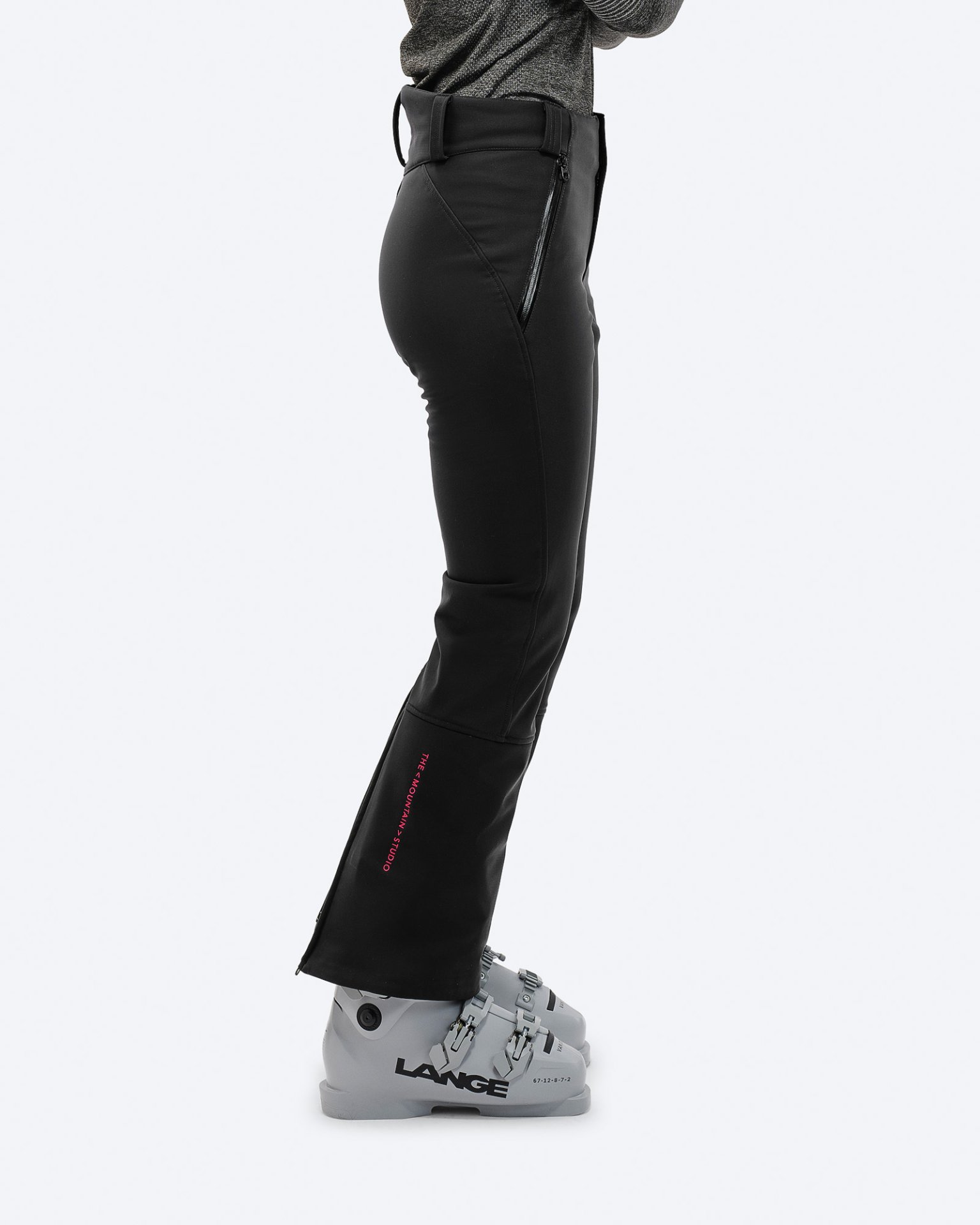 Eine Person in schwarzer P-4 W 2L Stretch Ski Pants mit Skischuhen, seitliche Ansicht.