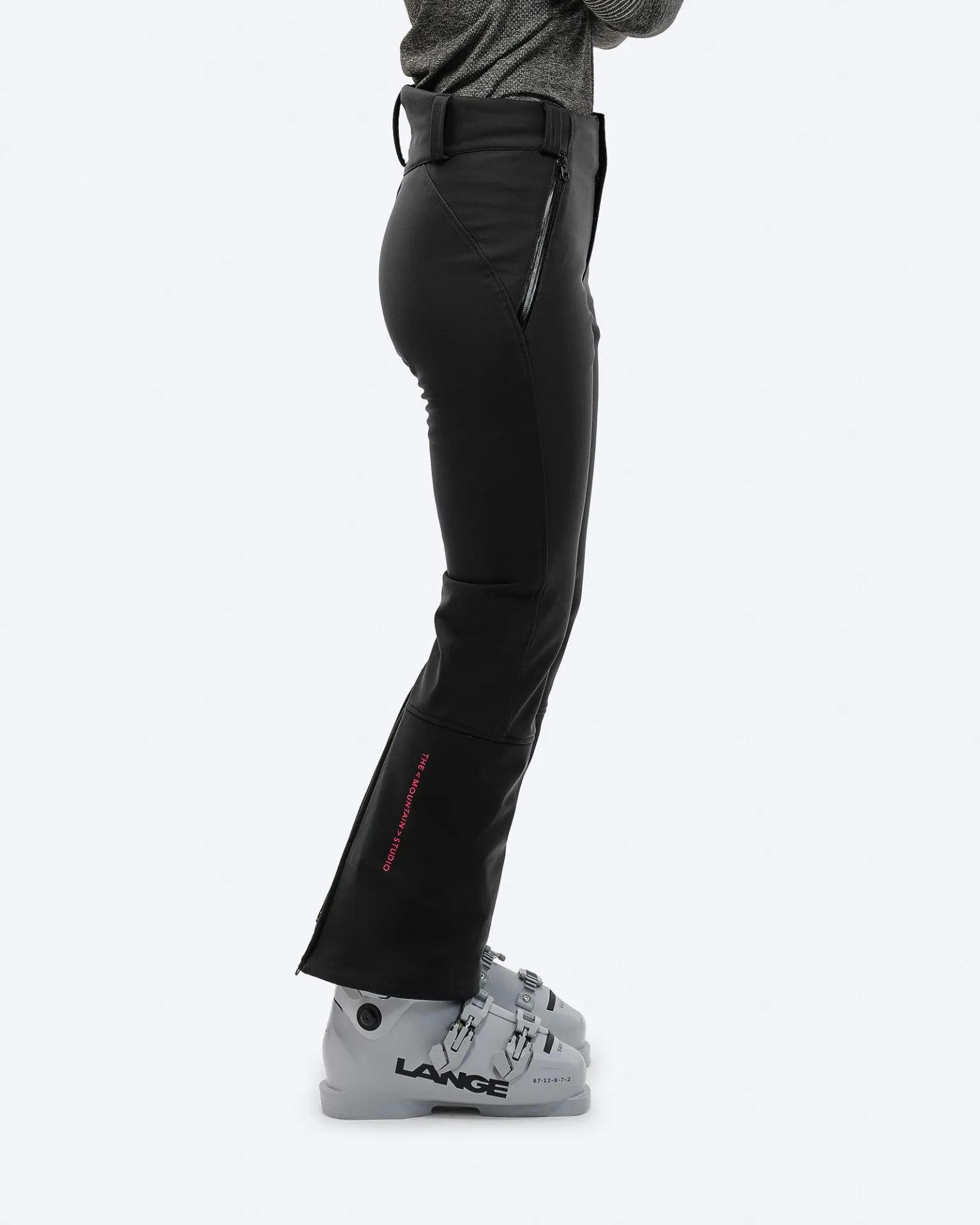 Eine Person in schwarzer P-4 W 2L Stretch Ski Pants mit Skischuhen, seitliche Ansicht.