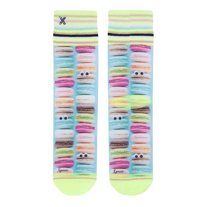 Ein Paar XPOOOS Socken mit Macarons Muster und kleinen Augen auf blauem Hintergrund.