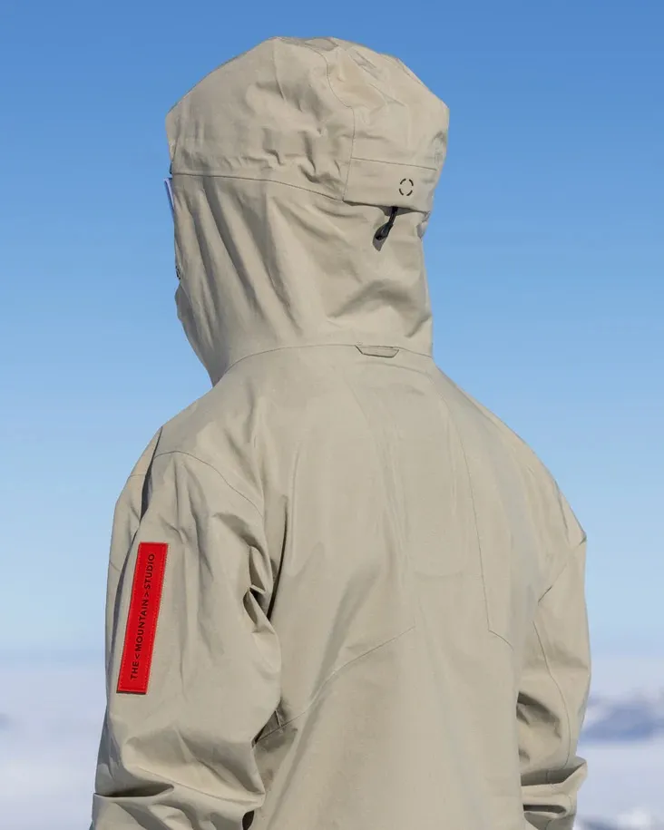 Rückenansicht der Z-2 EPE 3L Jacket in Seneca Rock. Die Jacke hat eine Kapuze und ein rotes Logo am Arm.