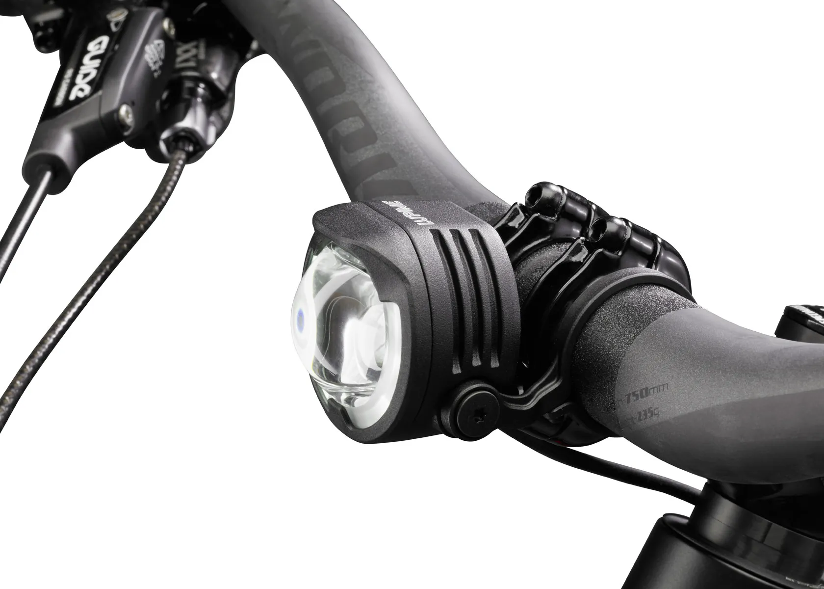 Nahaufnahme: Lupine E-Bike Beleuchtung am Fahrradlenker montiert. Die Lampe ist schwarz und hat ein klares Glas.