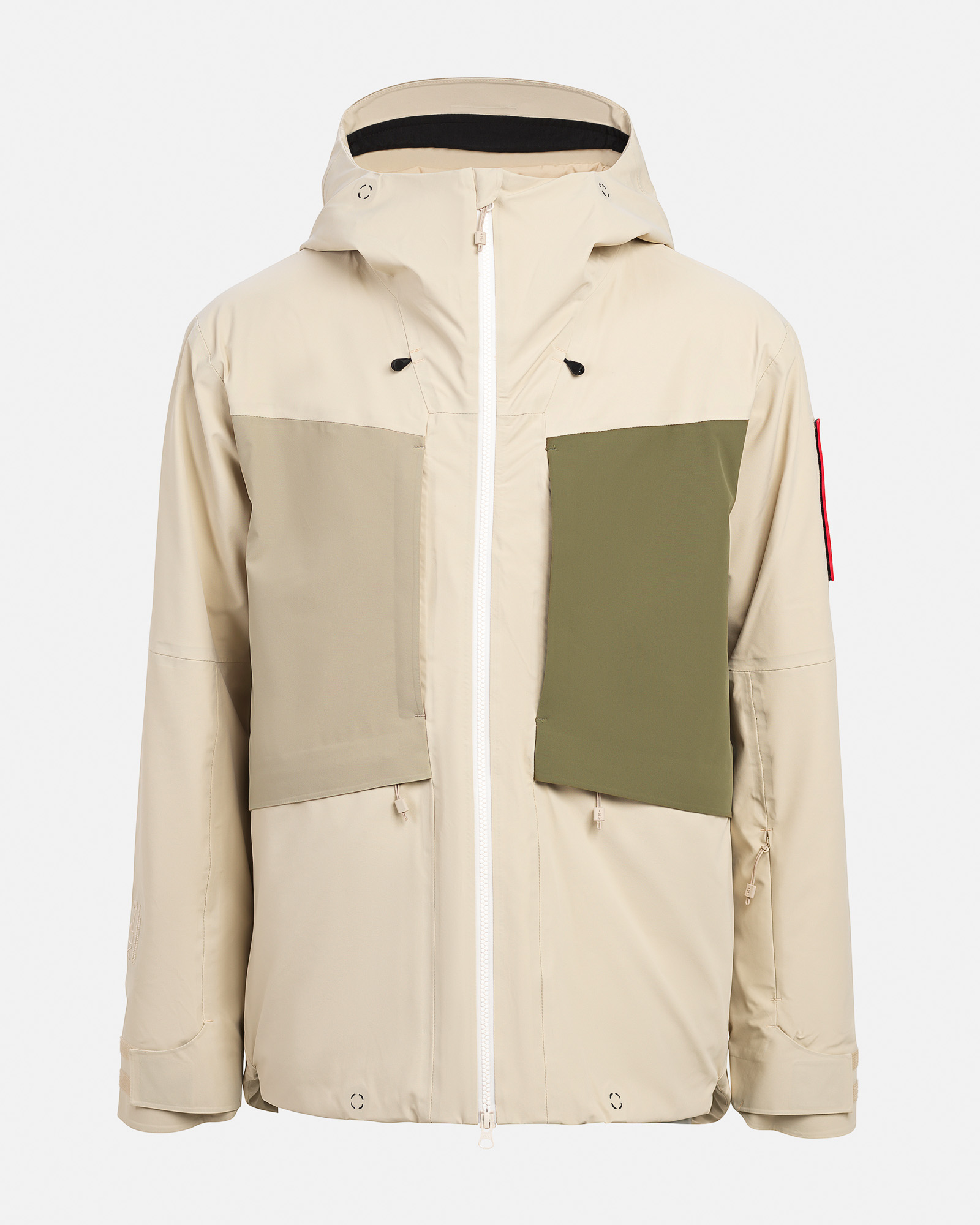 Sandfarbene 3L Hybrid Shell Jacke mit Kapuze, weißen Reißverschluss und grüner Brusttasche.