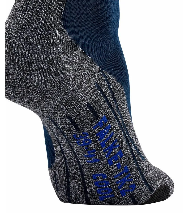 Nahaufnahme einer grauen Trekking Socke mit blauer Ferse und blauem Falke-Logo.
